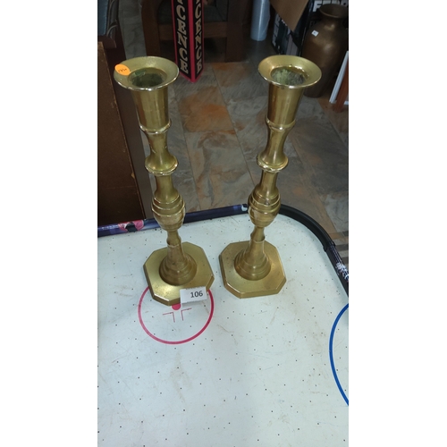 106 - Pair of tall turned brass candlesticks with stepped, octagonal bases, early–mid 20th century.