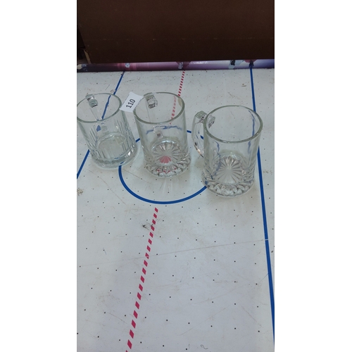 110 - Set of three clear pressed-glass beer tankards with starburst-cut bases.