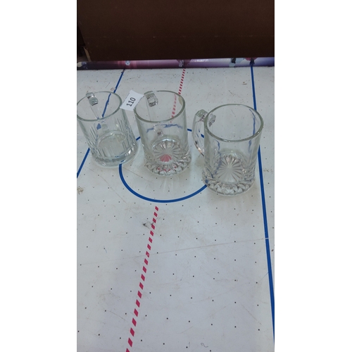 110 - Set of three clear pressed-glass beer tankards with starburst-cut bases.