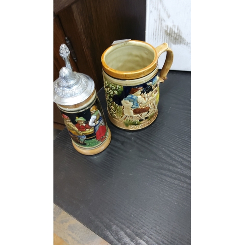 73 - Two German moulded pottery beer steins, one open, one with hinged pewter lid, each with polychrome r... 