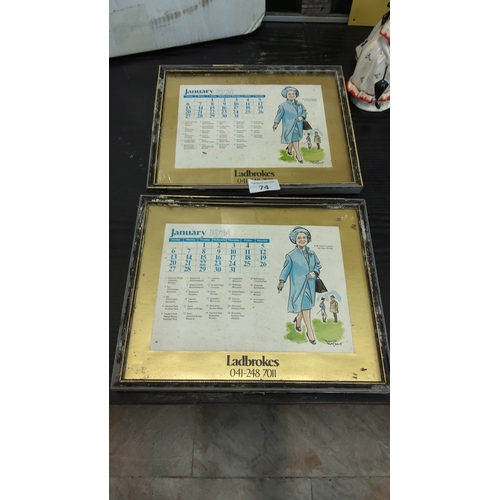 74 - Pair of framed gold-toned mirrored calendar plaques advertising Ladbrokes, each featuring January 19... 