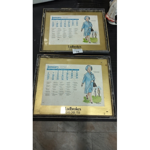 74 - Pair of framed gold-toned mirrored calendar plaques advertising Ladbrokes, each featuring January 19... 