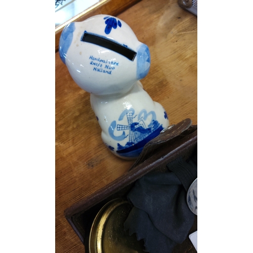 81 - Two-piece lot comprising a hand-painted Delft blue earthenware dog-form piggy bank marked “Handpaint... 