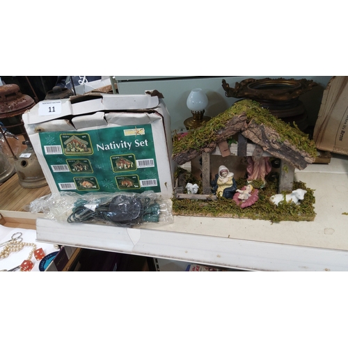 11 - Boxed nativity set comprising moss-roofed stable, resin Holy Family and animals, with integral 10-bu... 