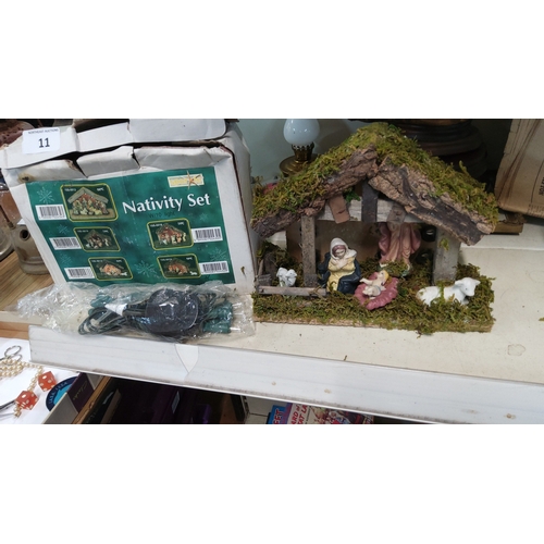 11 - Boxed nativity set comprising moss-roofed stable, resin Holy Family and animals, with integral 10-bu... 