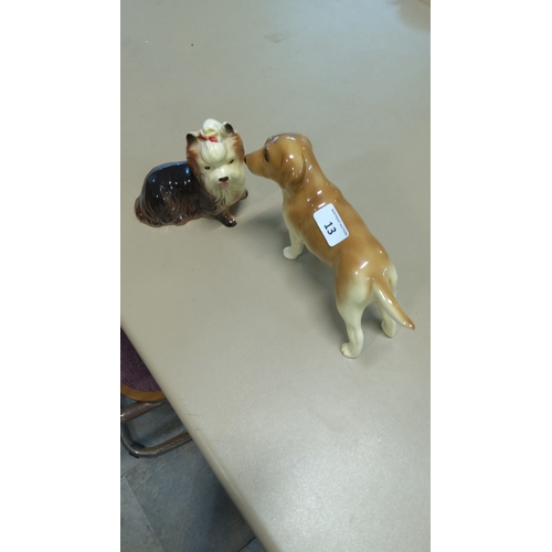 13 - Pair of glazed porcelain dog figurines: a seated Yorkshire terrier with red bow and a standing golde... 