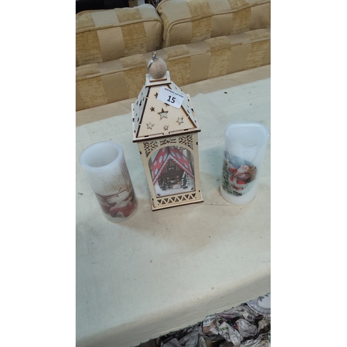 15 - Group of three battery-operated Christmas decorations comprising a laser-cut lantern with chalet sce... 