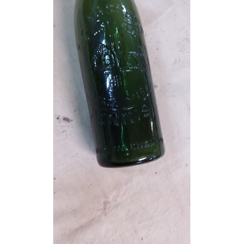 18 - Green glass beer or mineral water bottle embossed with a gothic church motif, legends including “Tra... 