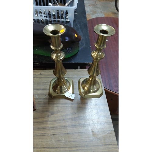 23 - Pair of solid brass candlesticks with baluster columns and octagonal stepped bases, Georgian revival... 