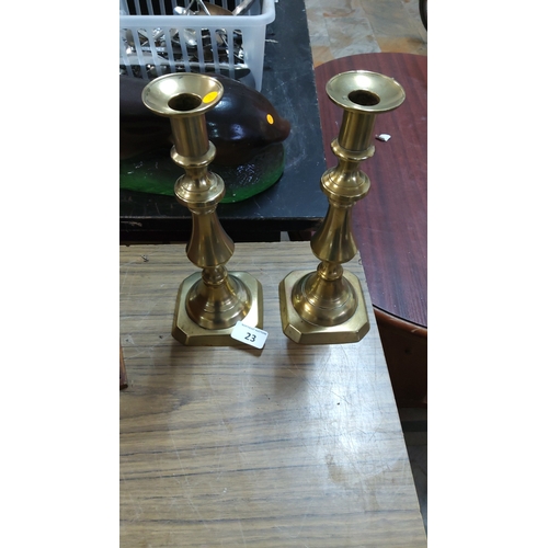 23 - Pair of solid brass candlesticks with baluster columns and octagonal stepped bases, Georgian revival... 