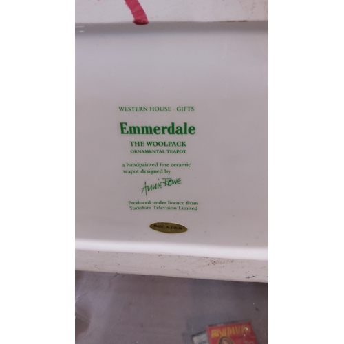 41 - Pair of Emmerdale television-themed ceramic teapots, comprising a cylindrical pot with printed homes... 