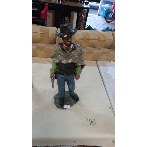 5 - Painted resin figure of poncho-clad cowboy with revolver and black hat, standing on rocky base, late... 