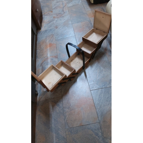 265 - Wooden cantilever sewing or craft box featuring four tiered trays, black metal scissor supports and ... 
