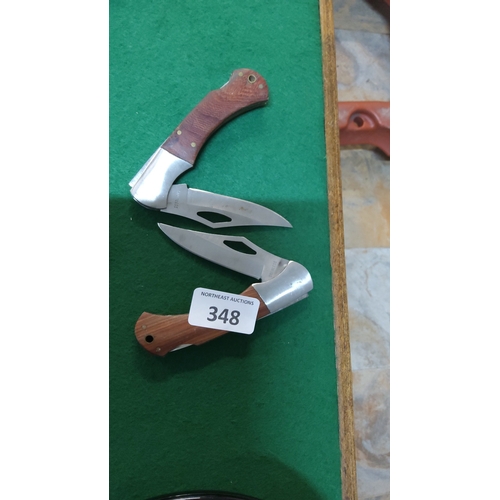 348 - Pair of stainless-steel folding pocket knives, each with clip-point blade and hardwood grip scales s... 