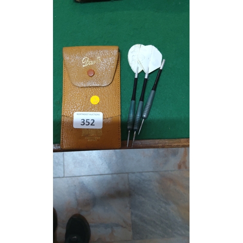 352 - Set of 3 steel-tip darts with ribbed alloy barrels, white flights, and a tan leather snap-closure po... 