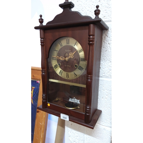 388 - Acctim wooden-cased pendulum wall clock, arched brass-tone Roman numeral dial, turned side columns a... 