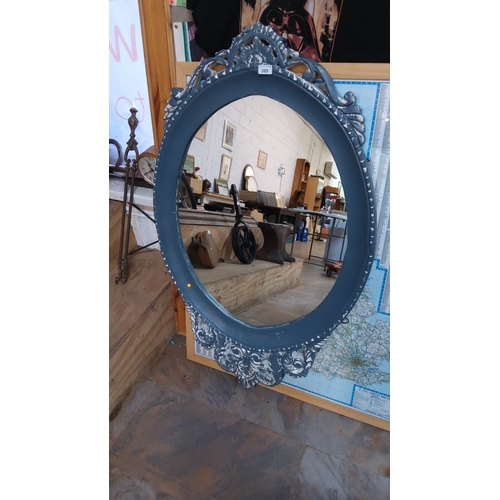 389 - Decorative circular wall mirror with pierced rococo-style crest and scrollwork frame, painted matte ... 