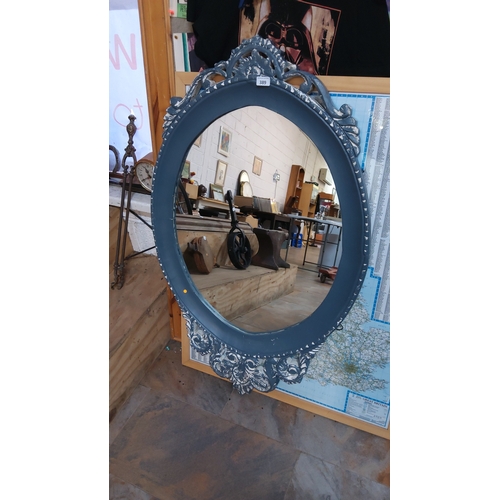 389 - Decorative circular wall mirror with pierced rococo-style crest and scrollwork frame, painted matte ... 
