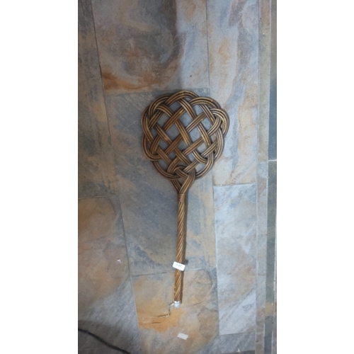 387 - Interlaced rattan carpet beater, the looped lattice head on a twisted cane handle, early to mid-20th... 