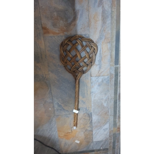 387 - Interlaced rattan carpet beater, the looped lattice head on a twisted cane handle, early to mid-20th... 