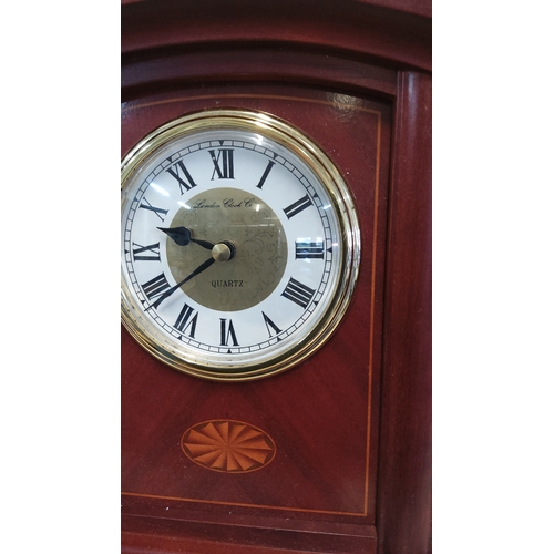 10 - A mantel clock with arched mahogany finish case, brass-tone bezel, Roman numeral dial signed London ... 
