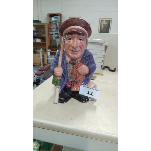 11 - A character ceramic figure of an elderly fisherman, modelled standing with fishing rod, net and fish... 