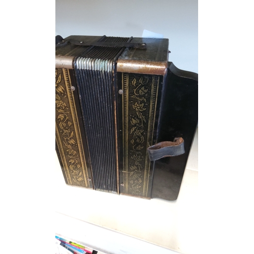 13 - A Hohner melodeon (diatonic button accordion), with black bellows and gilt floral decoration to the ... 