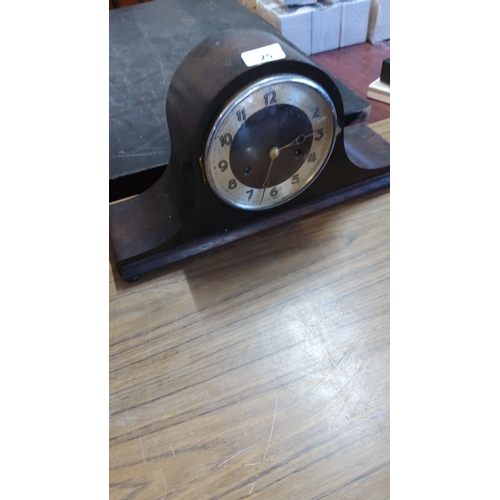 25 - A mantle clock with arched walnut-finish case and circular silvered Arabic dial, with central second... 