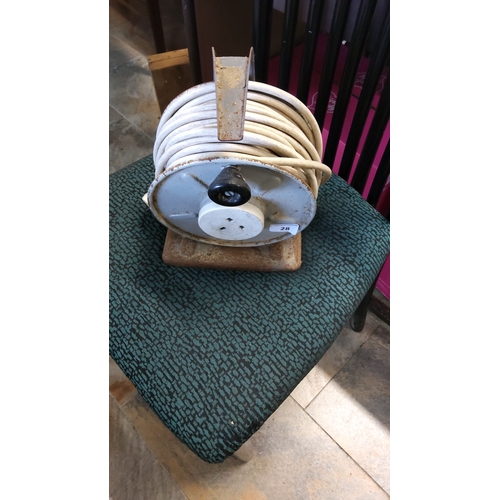 28 - A metal-framed cable reel fitted with a UK three-pin plug and socket, wound with a long length of pa... 