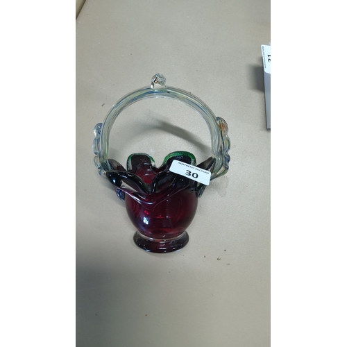 30 - A hand-blown art glass basket, the cranberry glass body with ruffled rim and green-to-black shaded e... 