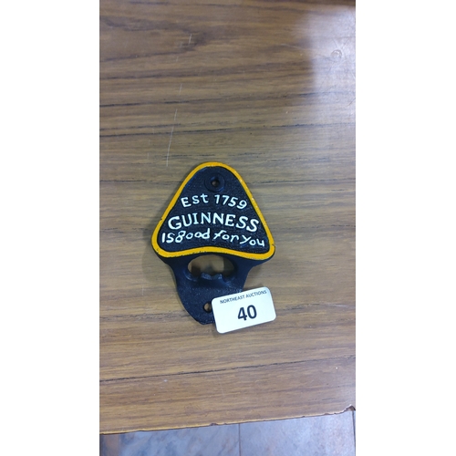 40 - A Guinness cast-iron wall-mounted bottle opener, triangular shield form with yellow border and raise... 