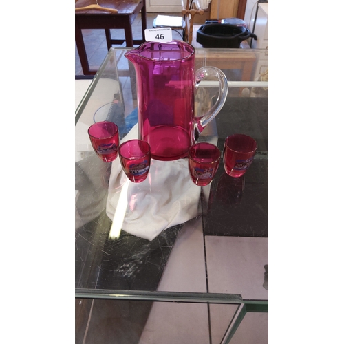 46 - Set of five cranberry-tinted glass items, comprising a clear-handled water jug and four matching sma... 