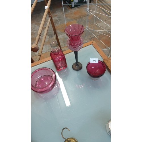 59 - Set of four cranberry glass items comprising a faceted stopper scent bottle with cut decoration, a f... 