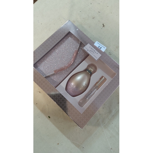 12 - Set of 3 ‘Lovely’ fragrance items, comprising a glitter-finish cosmetic pouch, a perfume bottle, and... 