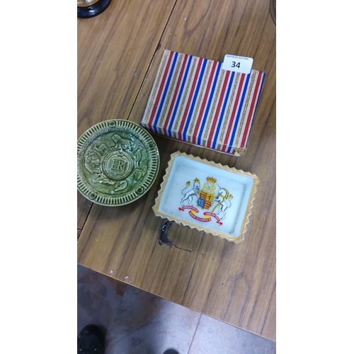 34 - Two Queen Elizabeth II coronation commemoratives, comprising a green glazed ceramic dish with crowne... 