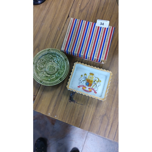 34 - Two Queen Elizabeth II coronation commemoratives, comprising a green glazed ceramic dish with crowne... 