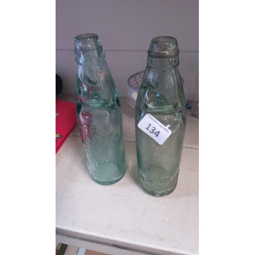 134 - A pair of moulded aqua glass Codd-neck bottles, each of tapering cylindrical form.(Manchester & Carl... 