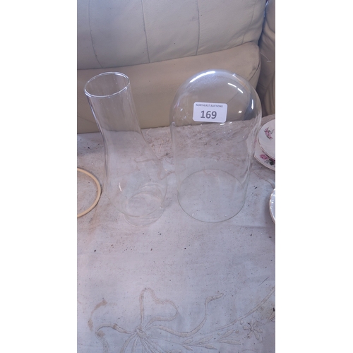 169 - A pair of clear glass vessels comprising a tapering oil lamp chimney and a domed cloche, each with p... 