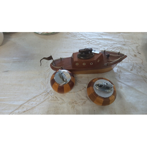 174 - A group of vintage novelty table lighters comprising a carved wooden boat-form example with porthole... 