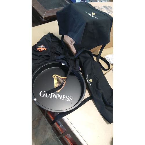 21 - A group of Guinness branded hospitality textiles and servingware, comprising black embroidered apron... 