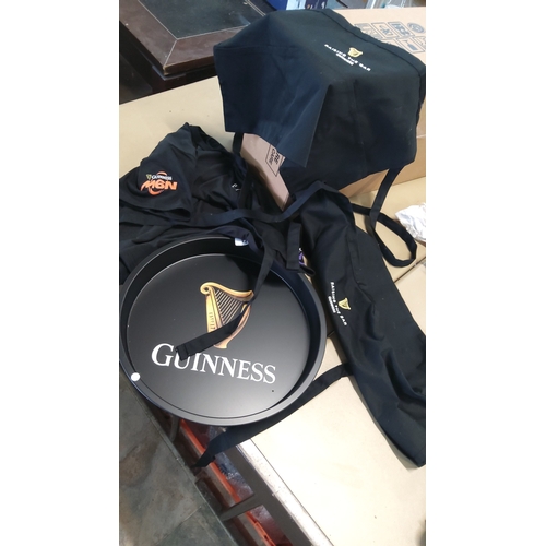 21 - A group of Guinness branded hospitality textiles and servingware, comprising black embroidered apron... 