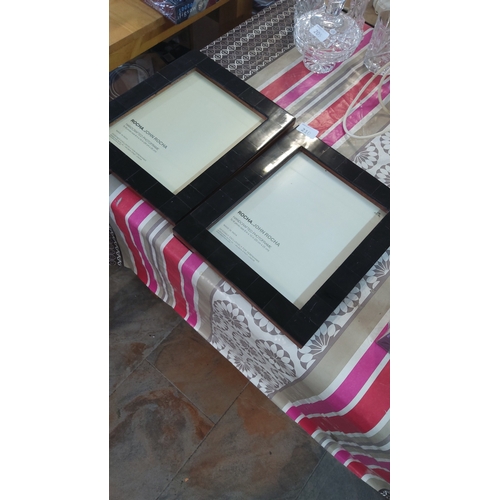 210 - A pair of Rocha John Rocha handcrafted photograph frames, with wide ebonised square-section borders ... 