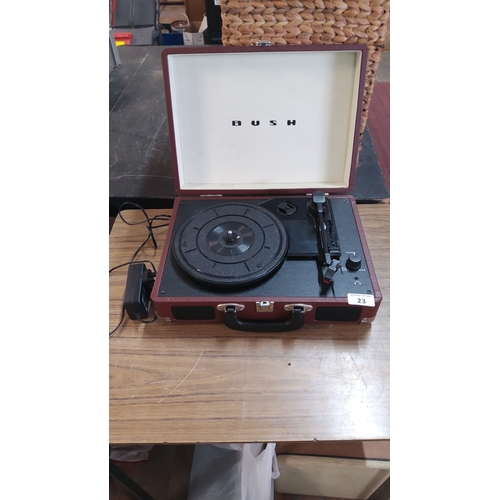 23 - Bush portable record player in a suitcase-style case, the hinged lid printed BUSH (w)