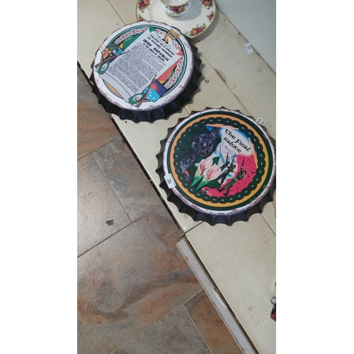 26 - Two bottle-cap form metal wall plaques, printed with Irish-themed graphics: one centred with the tex... 
