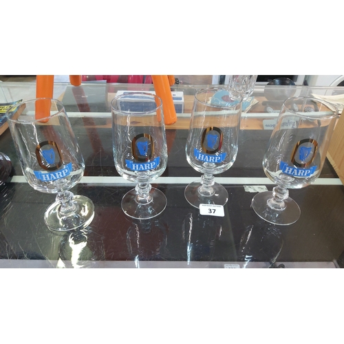 37 - A group of Harp Lager branded stemmed beer goblets, each of tulip form with printed harp emblem and ... 