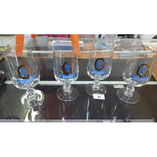 37 - A group of Harp Lager branded stemmed beer goblets, each of tulip form with printed harp emblem and ... 