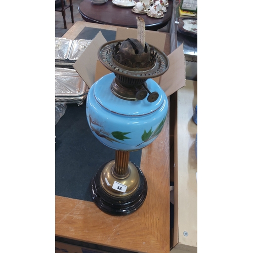 38 - A Victorian-style oil lamp with brass burner and chimney gallery, the blue opaline glass font enamel... 