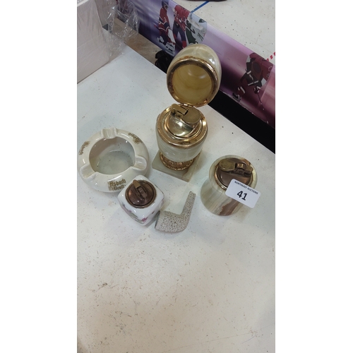 41 - A group of tobacco accessories comprising an onyx-style table lighter with hinged cover and square b... 