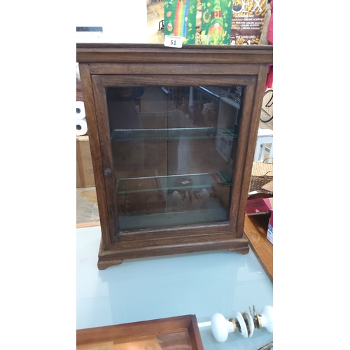 51 - Vintage glazed heavy oak counter top shop cabinet, the moulded cornice above a single hinged glass d... 