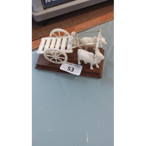 53 - Carved ivory tone model of an ox-drawn cart with standing driver, the slatted two-wheeled vehicle ha... 